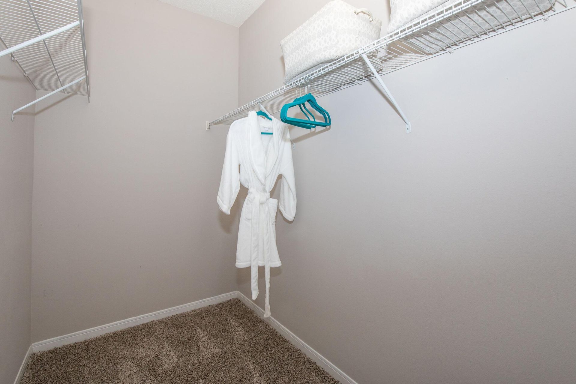 A walk in closet with a robe hanging on a rack.