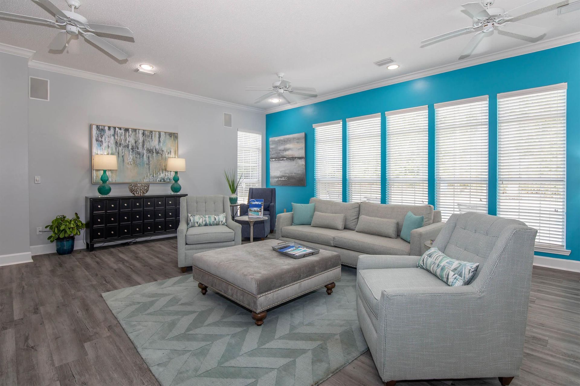 Summer Trace at Gulf Shores spacious clubhouse with sofa, blue wall, and oversized windows. 