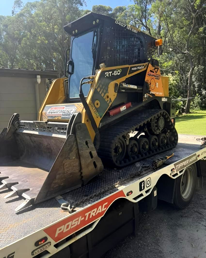 A Small Bulldozer Is Sitting on Top of a Tow Truck — R&J Cronin Equipment Hire in Bonnells Bay, Nsw