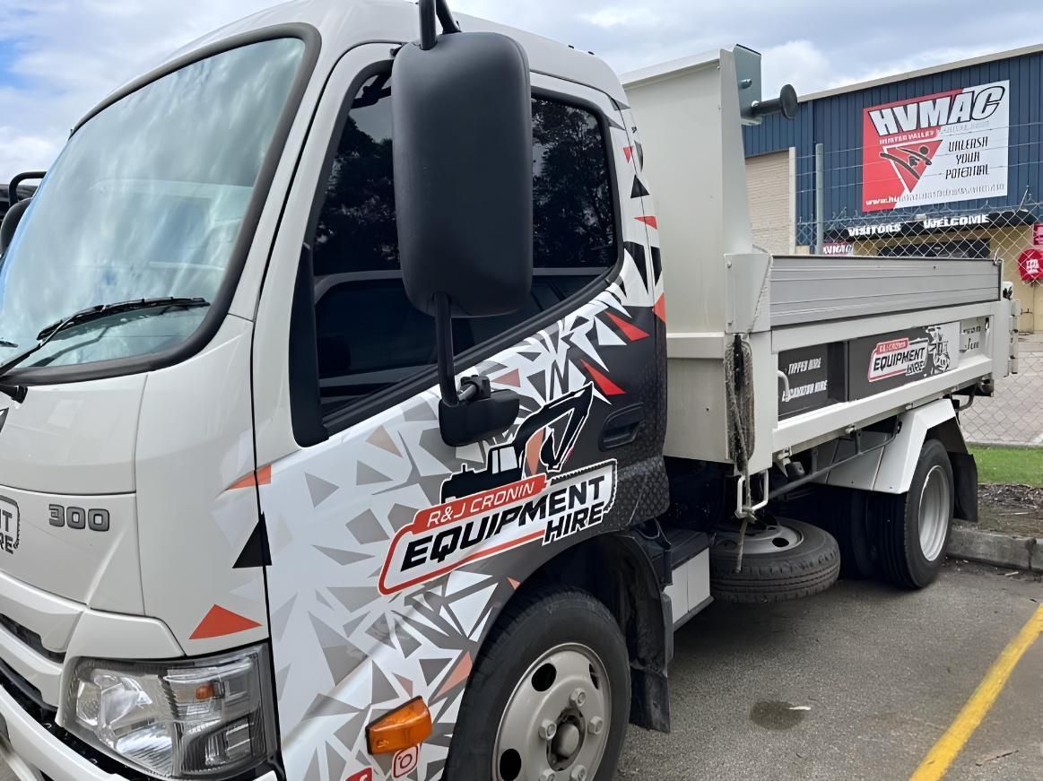 A White Dump Truck Is Parked at A Parking Lot — R&J Cronin Equipment Hire in Wyee, NSW