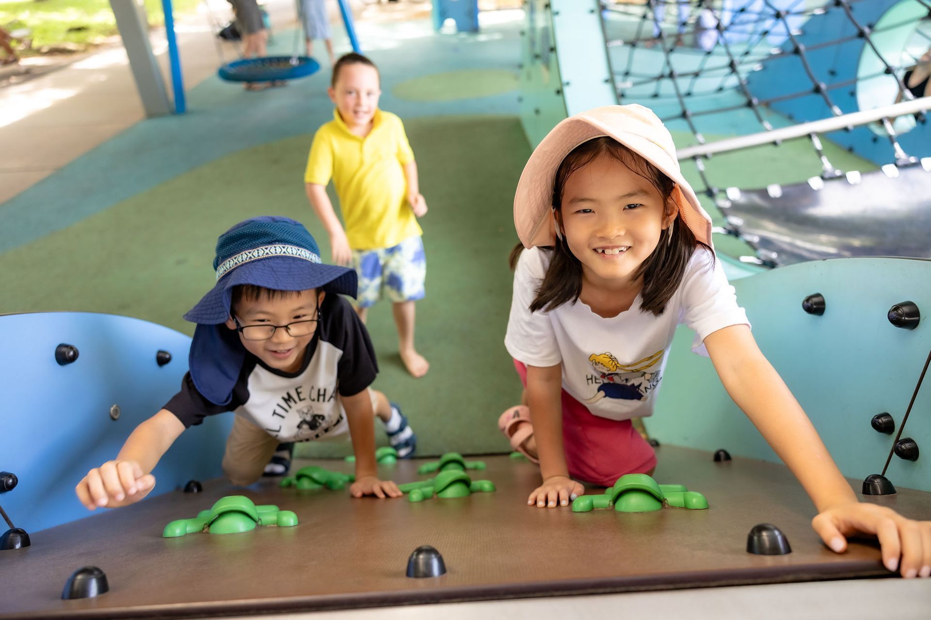 Children playing on climbing equipment at a playground.