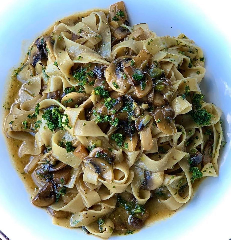 Pasta dish with mushrooms and green herbs.