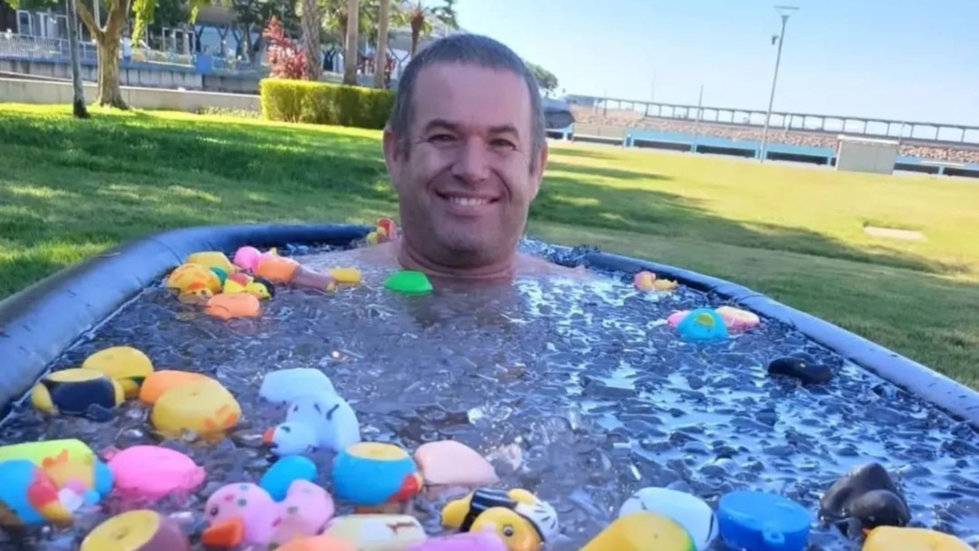 Boy sliding across a blue water slide.