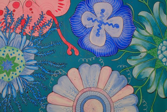 Floral pattern with blue, pink, and green blooms on a teal background.