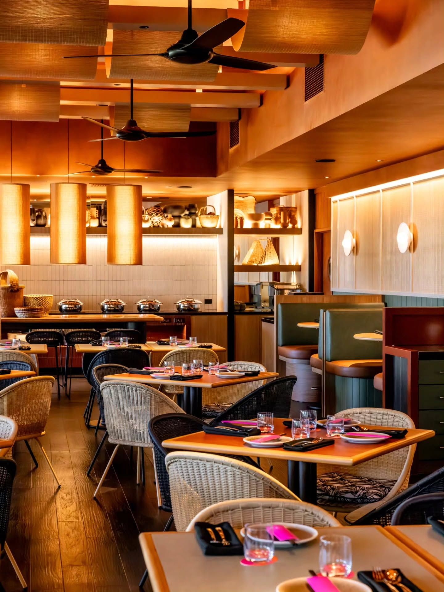 Restaurant interior with wooden floor, tables, chairs, and large windows. Decorated columns.