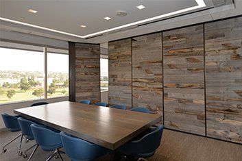 A conference room with a long wooden table and blue chairs.