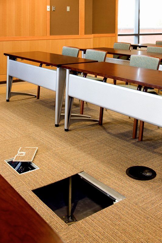 A conference room with tables and chairs and a hole in the floor