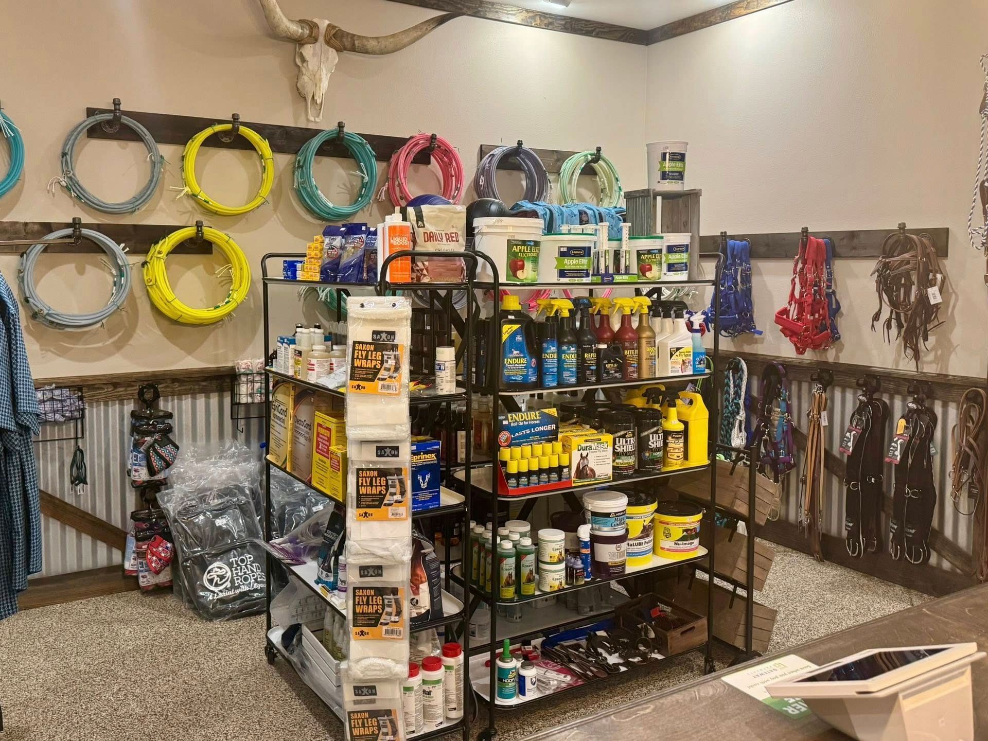 A retail store displays equestrian equipment, ropes, and supplies