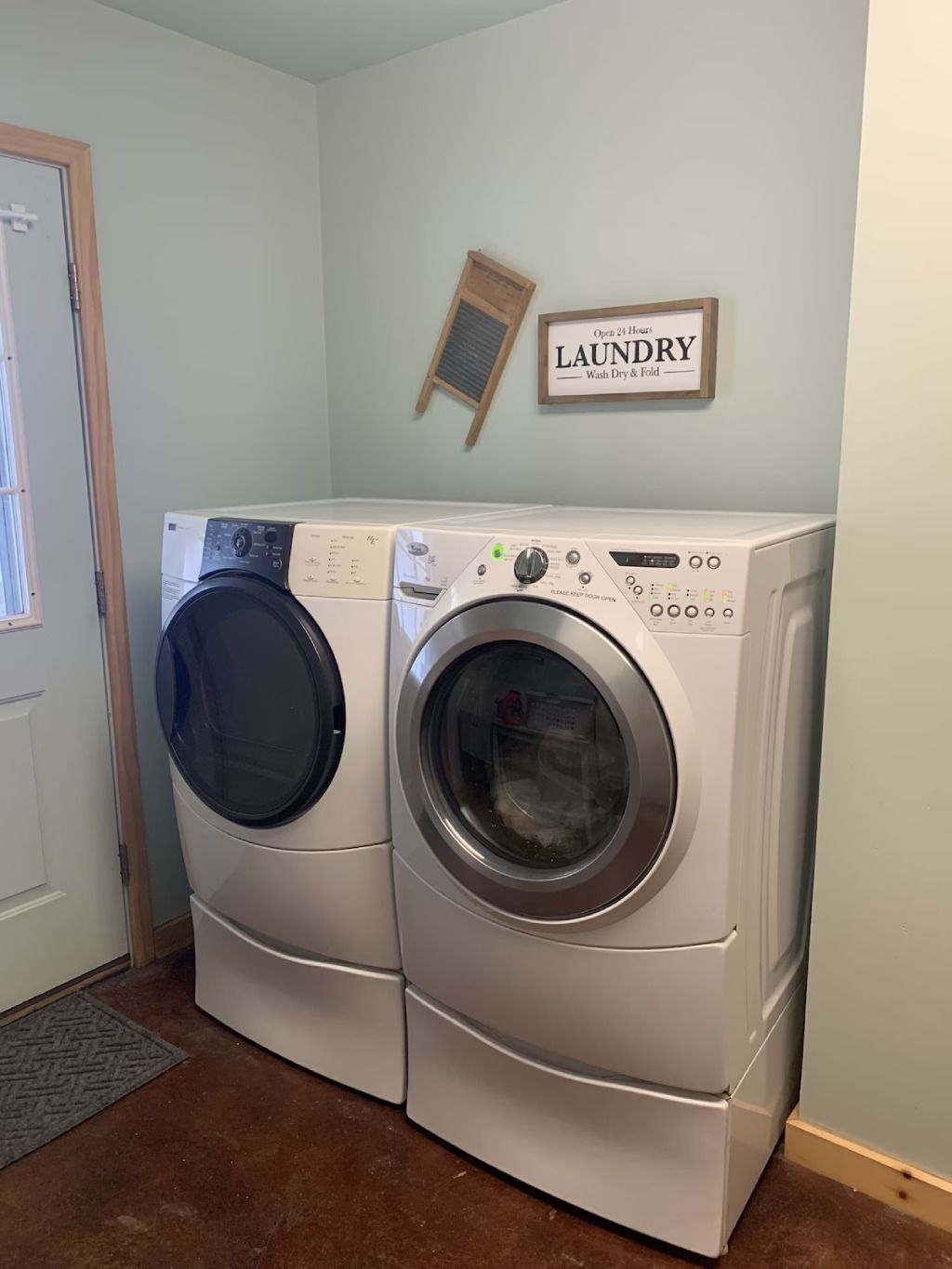 A laundry room with a washer and dryer and a sign that says laundry.