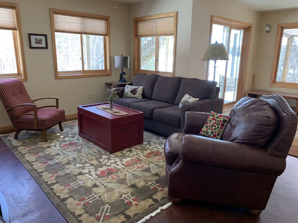 A living room with a couch , chairs , and a coffee table.