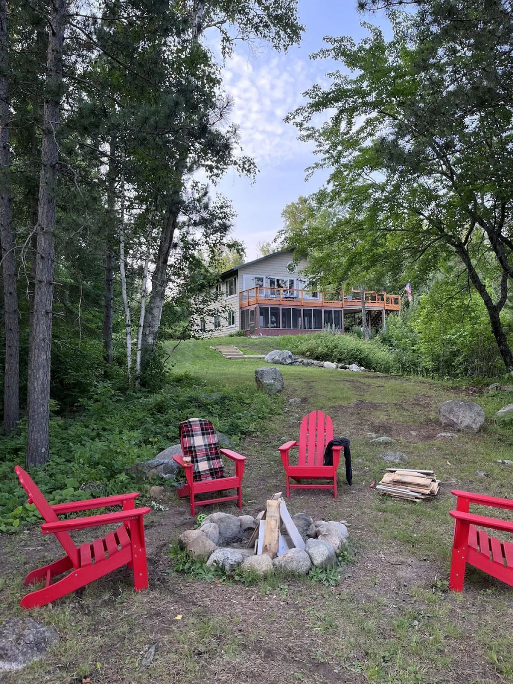 A group of red chairs are sitting around a fire pit.