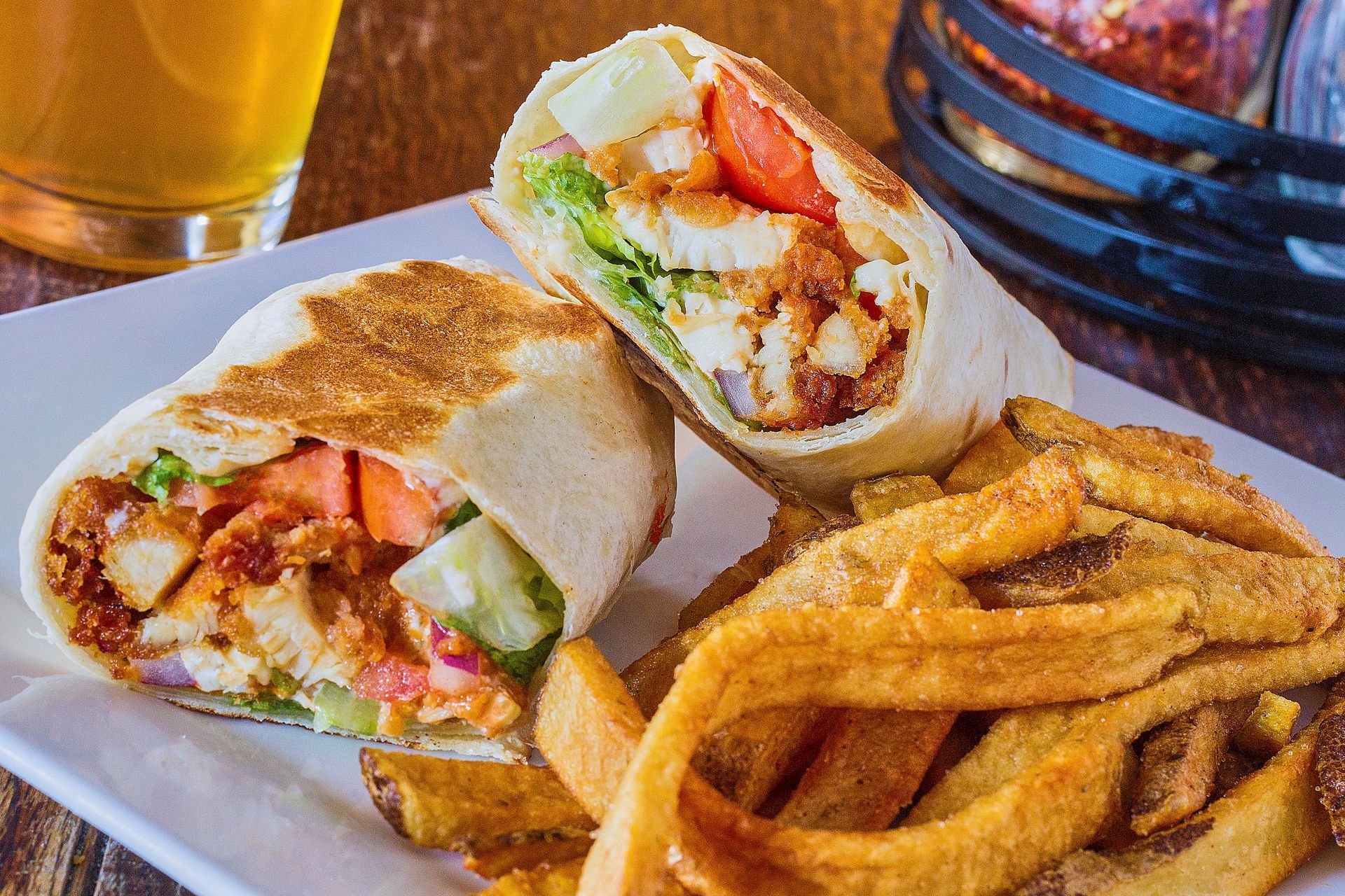 A wooden cutting board topped with chicken wings and onion rings