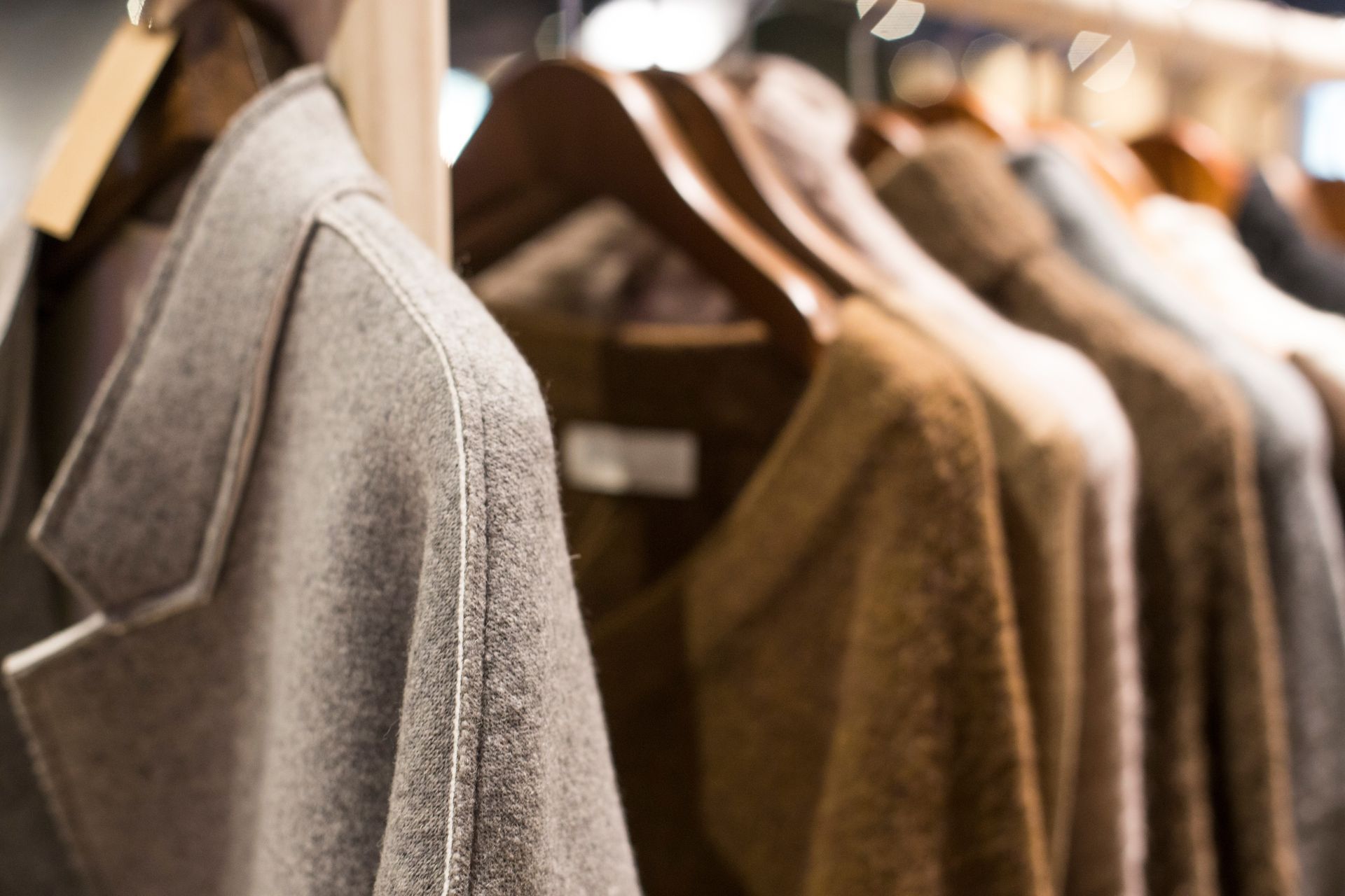 A row of clothes hanging on a rack in a store.