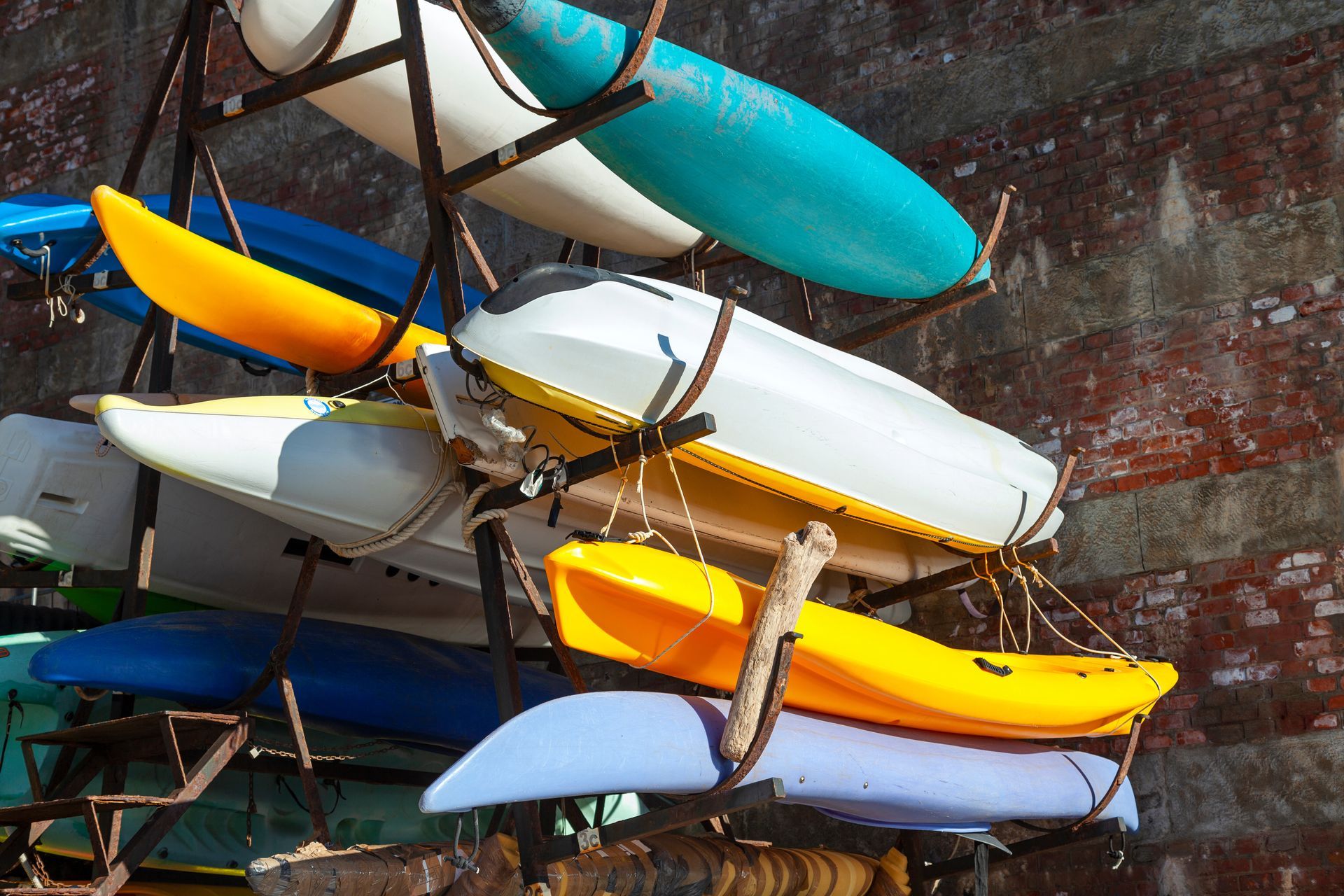 A bunch of kayaks are stacked on top of each other