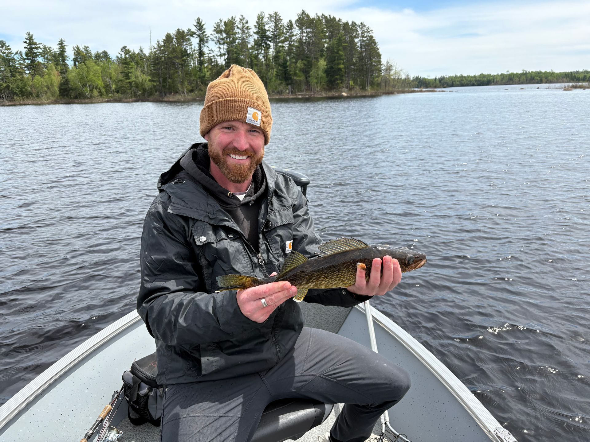 A kitchen with wooden cabinets , stainless steel appliances , and a large island.
