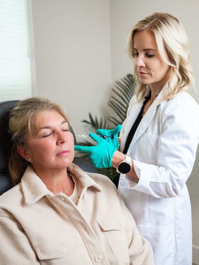 a woman is getting an injection in her face by a doctor .