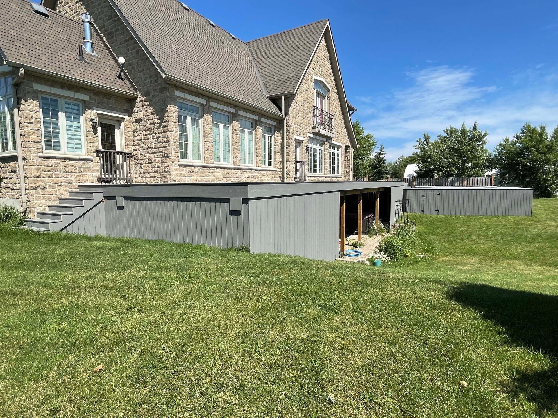 A large brick house with a large lawn in front of it.