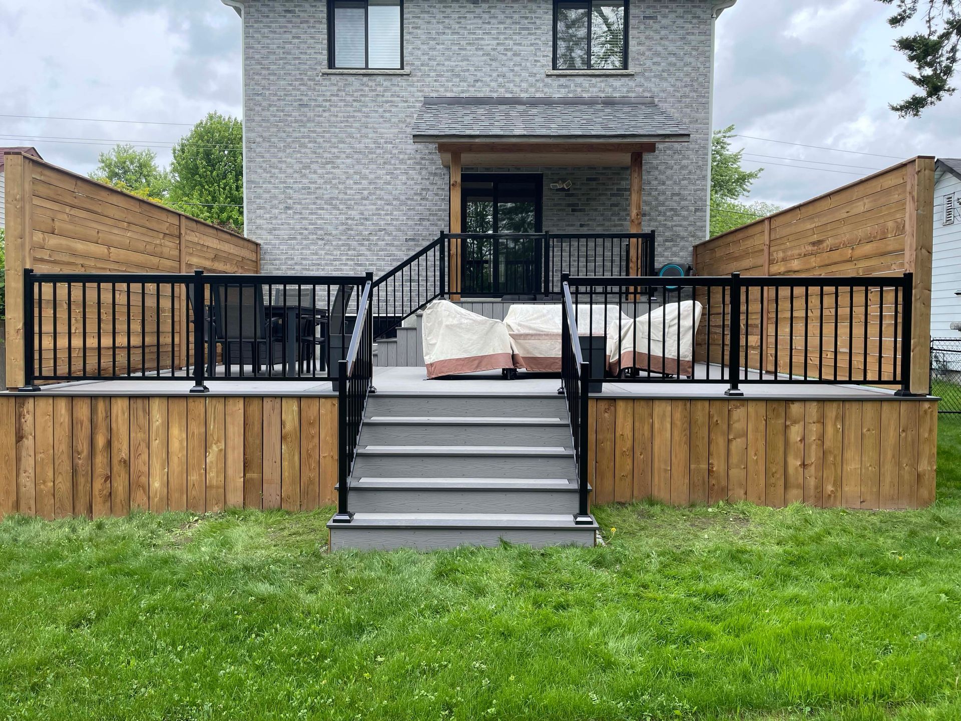 The backyard of a house with a deck and stairs.