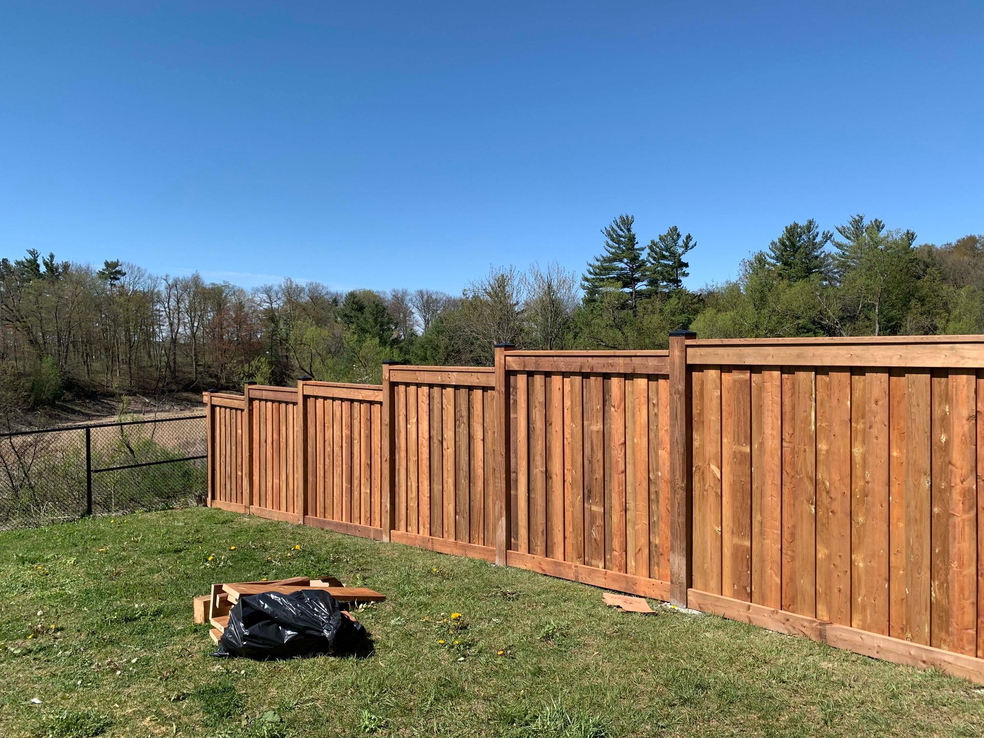 A wooden fence is sitting in the middle of a lush green field.