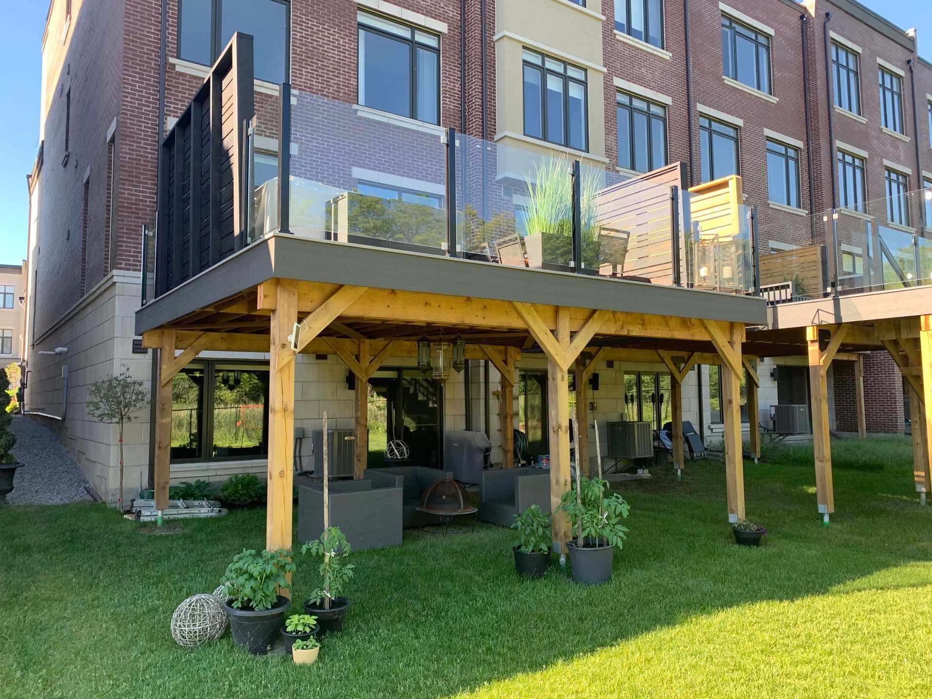 A large brick building with a wooden deck and a glass railing.