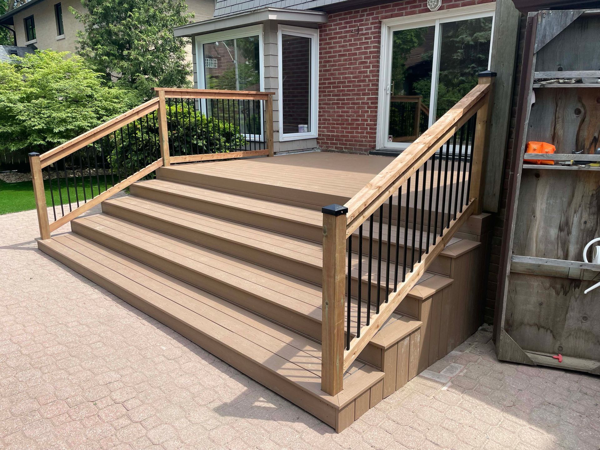 A wooden deck with stairs and a metal railing