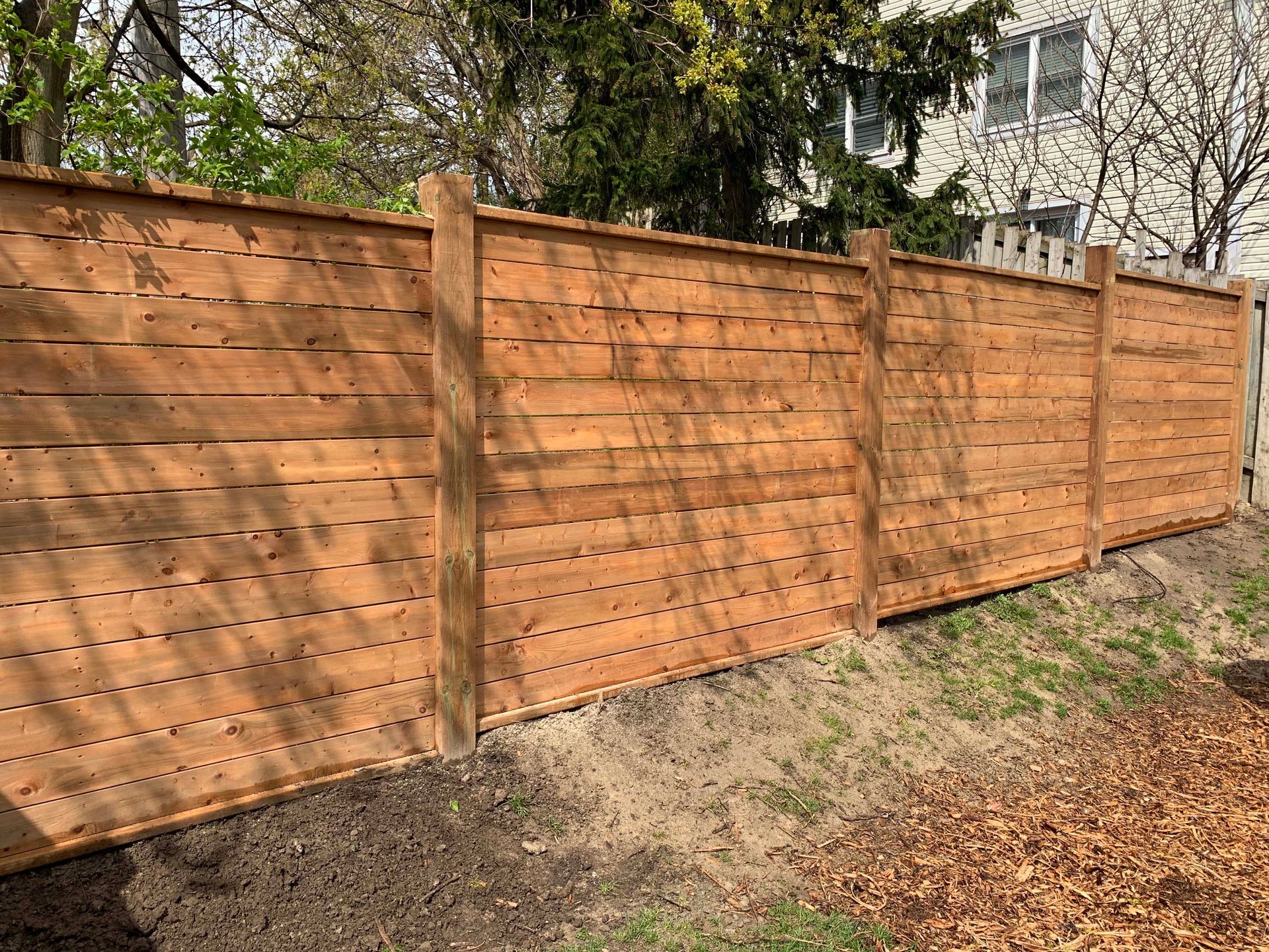 A wooden fence is sitting in the middle of a yard.