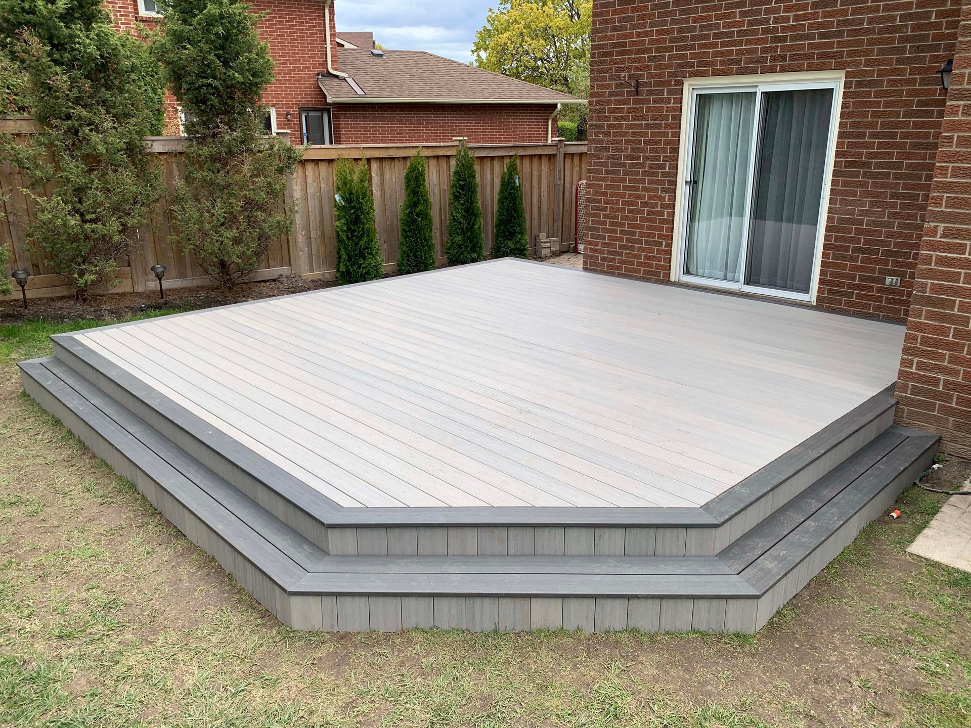 A brick house with a large deck in front of it.