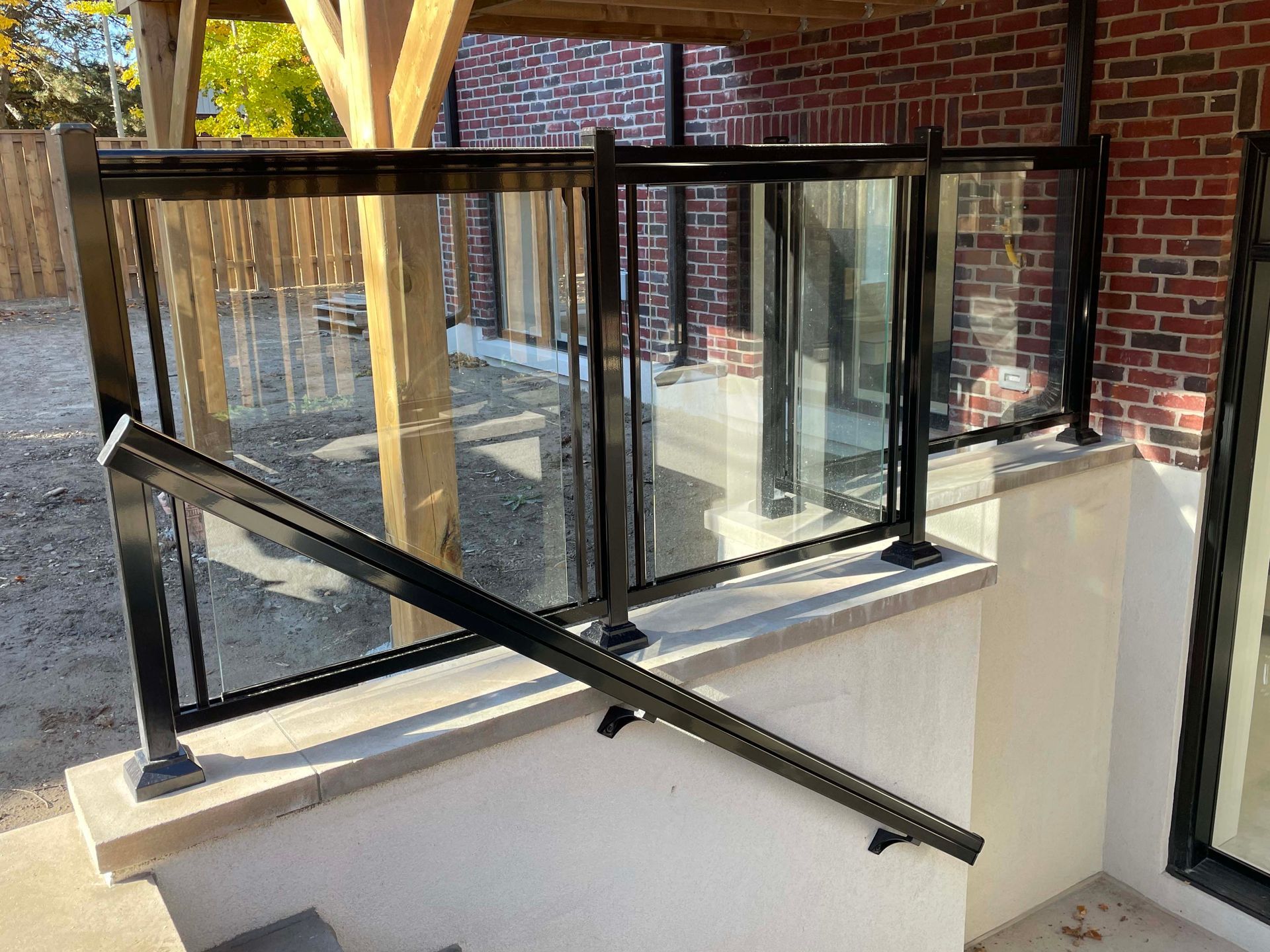 A balcony with a glass railing and stairs leading up to it.