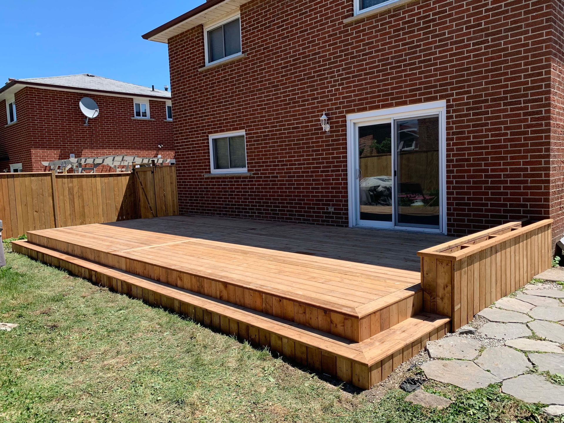 A brick house with a wooden deck in front of it.