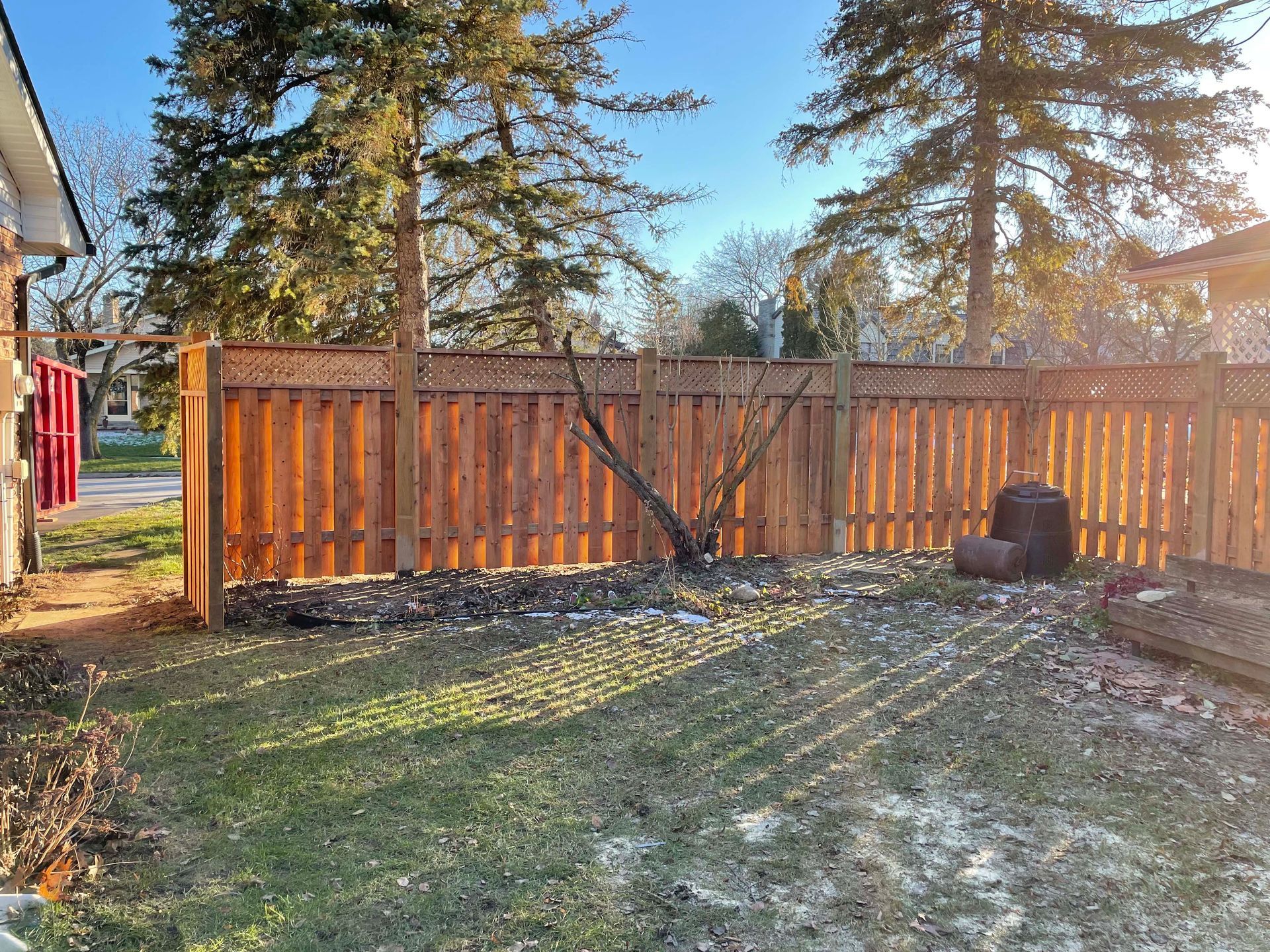There is a wooden fence in the backyard of a house.