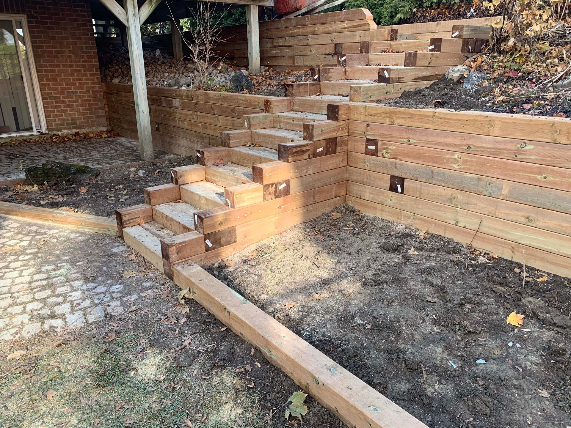 A wooden retaining wall with stairs built into it.