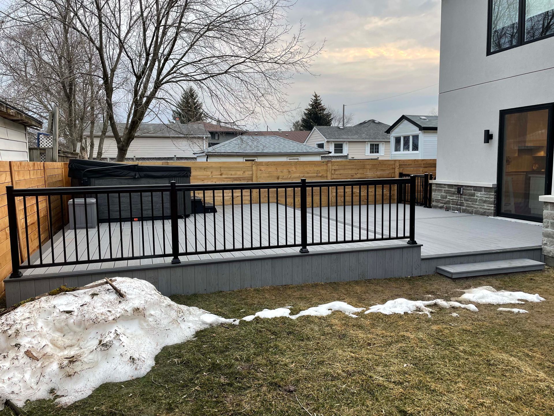There is a hot tub on the deck of a house.