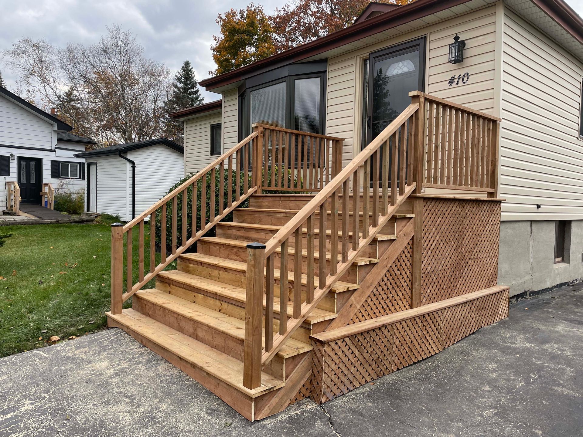 A house with a wooden deck and stairs leading up to it.