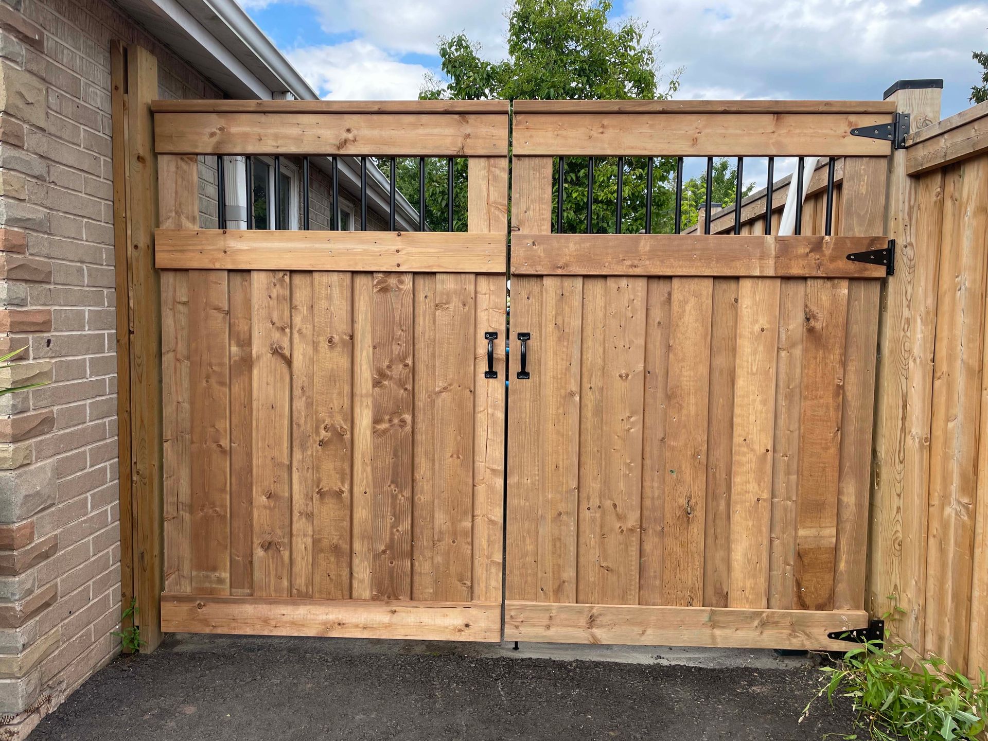 A wooden gate is sitting in front of a brick building.