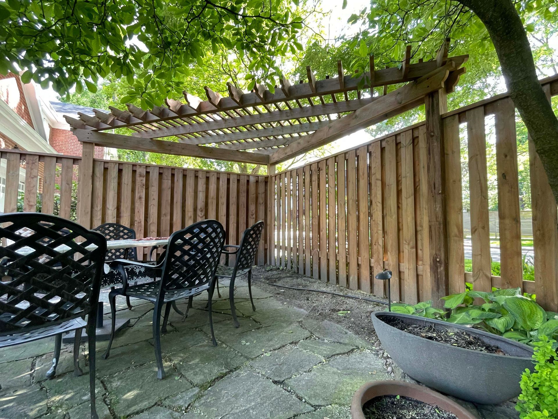 A patio with a table and chairs under a pergola.