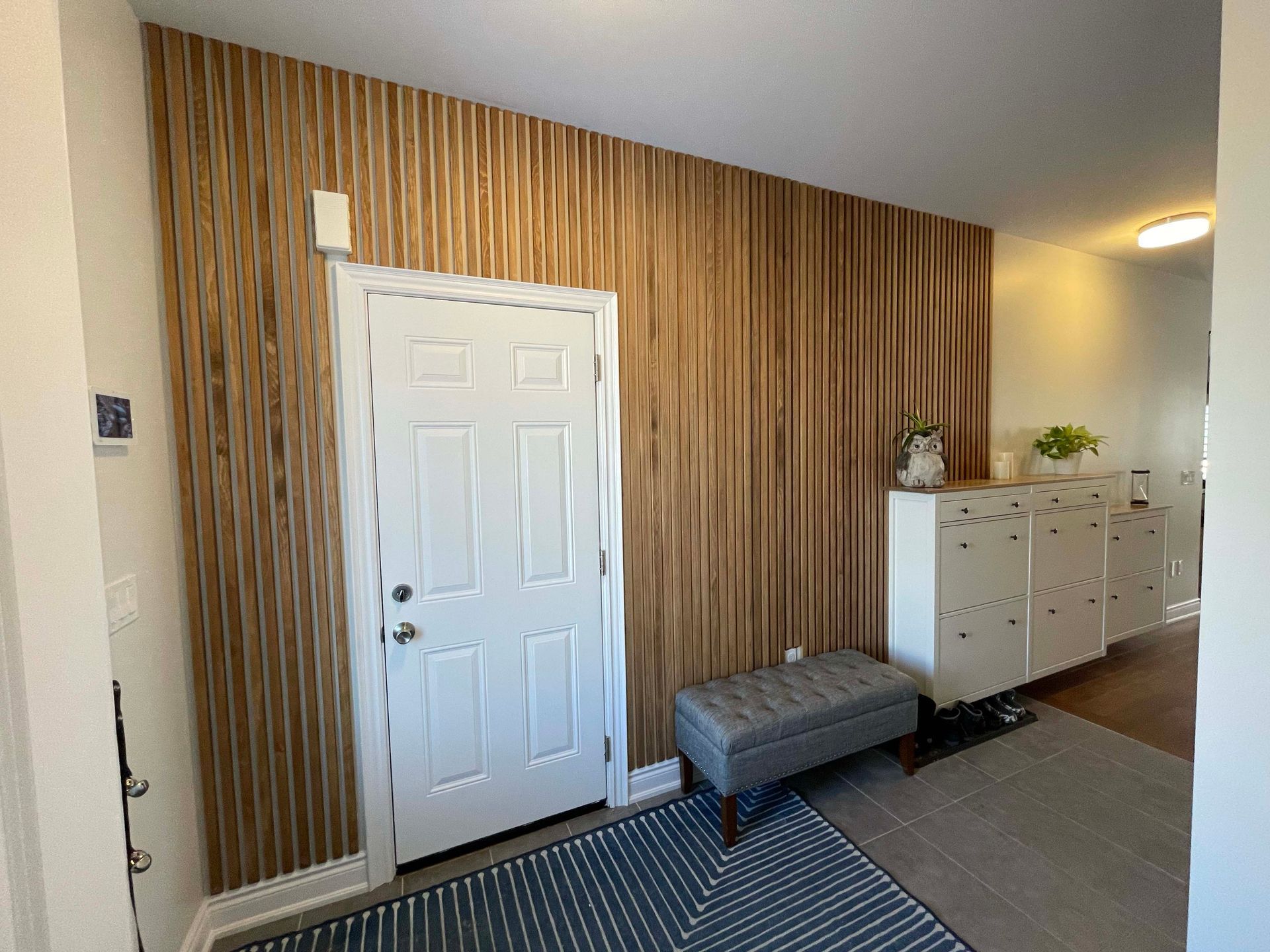A hallway with a wooden wall and a white door.
