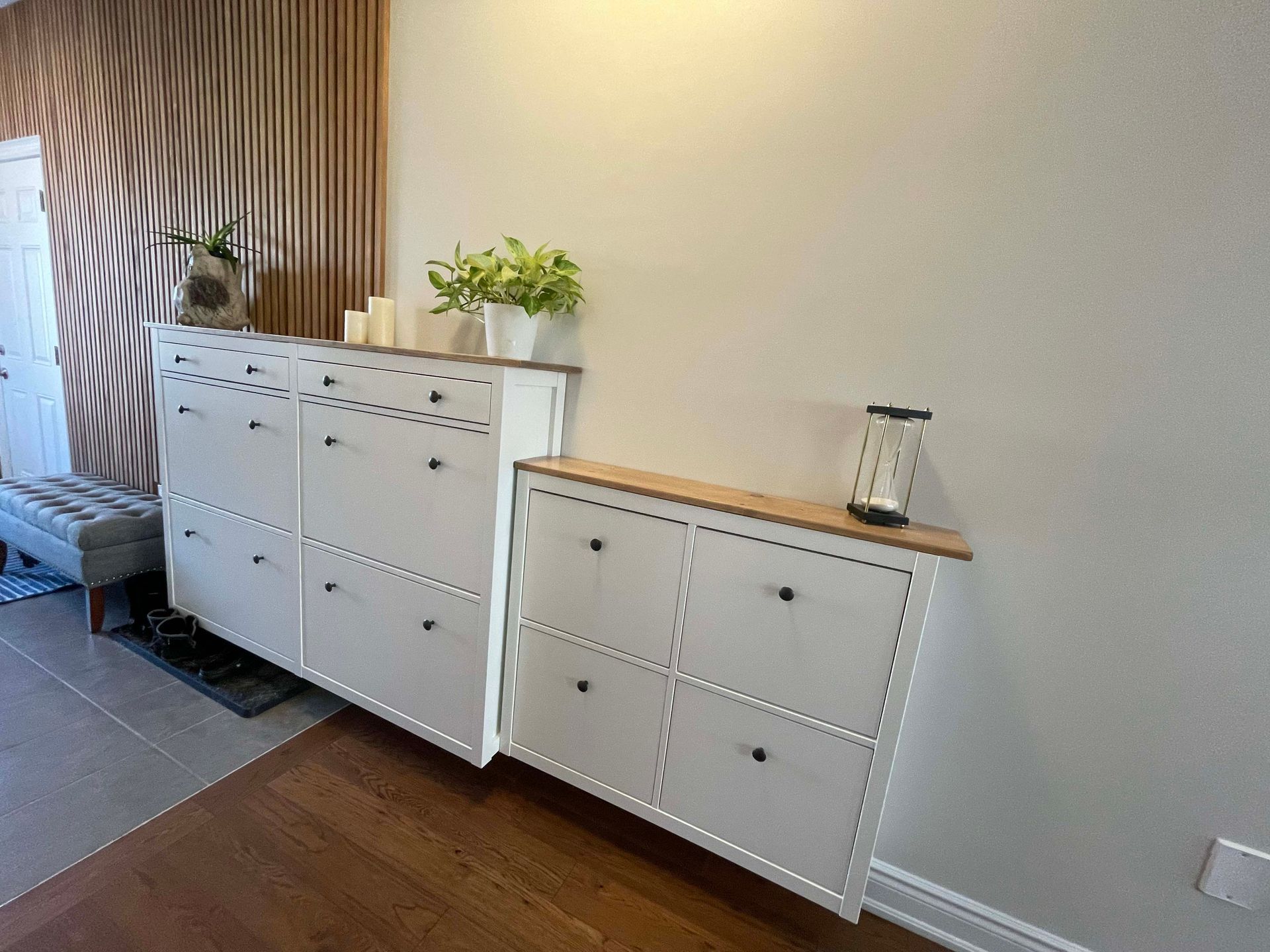 A hallway with a dresser and a shoe rack.