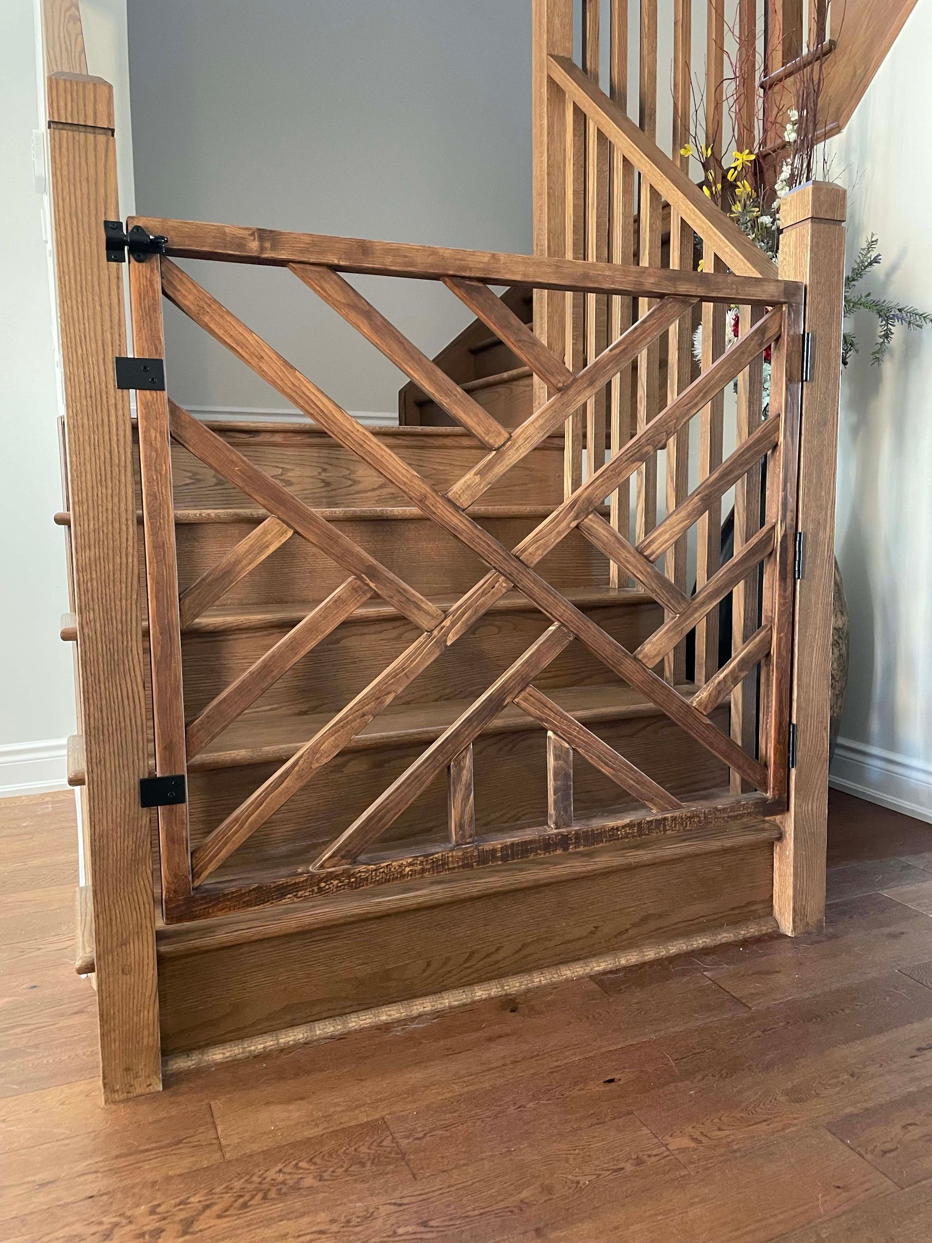 A wooden gate is attached to a wooden staircase.