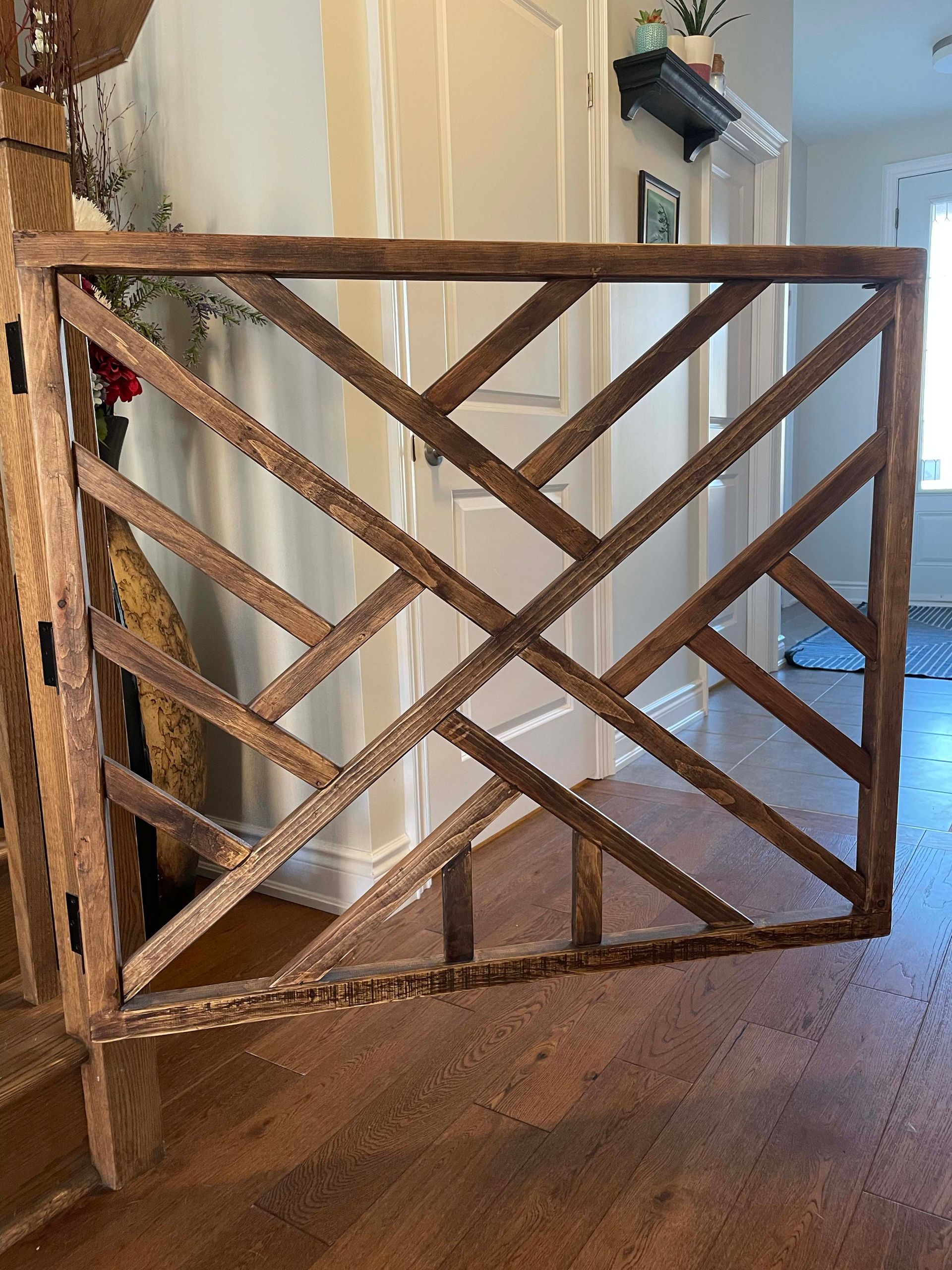 A wooden fence is sitting on a wooden floor in a room.