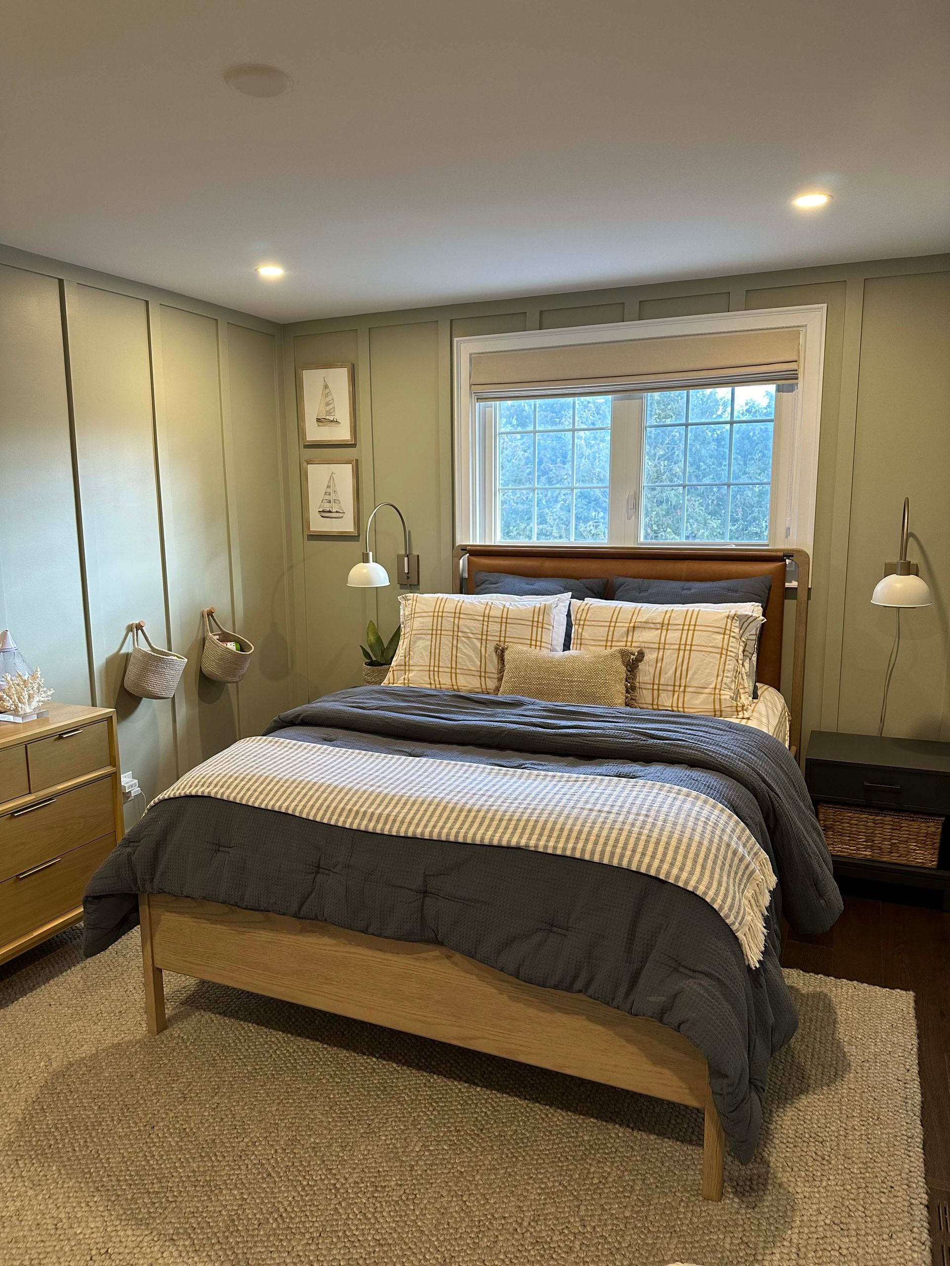 A bedroom with a bed , dresser , nightstand and window.