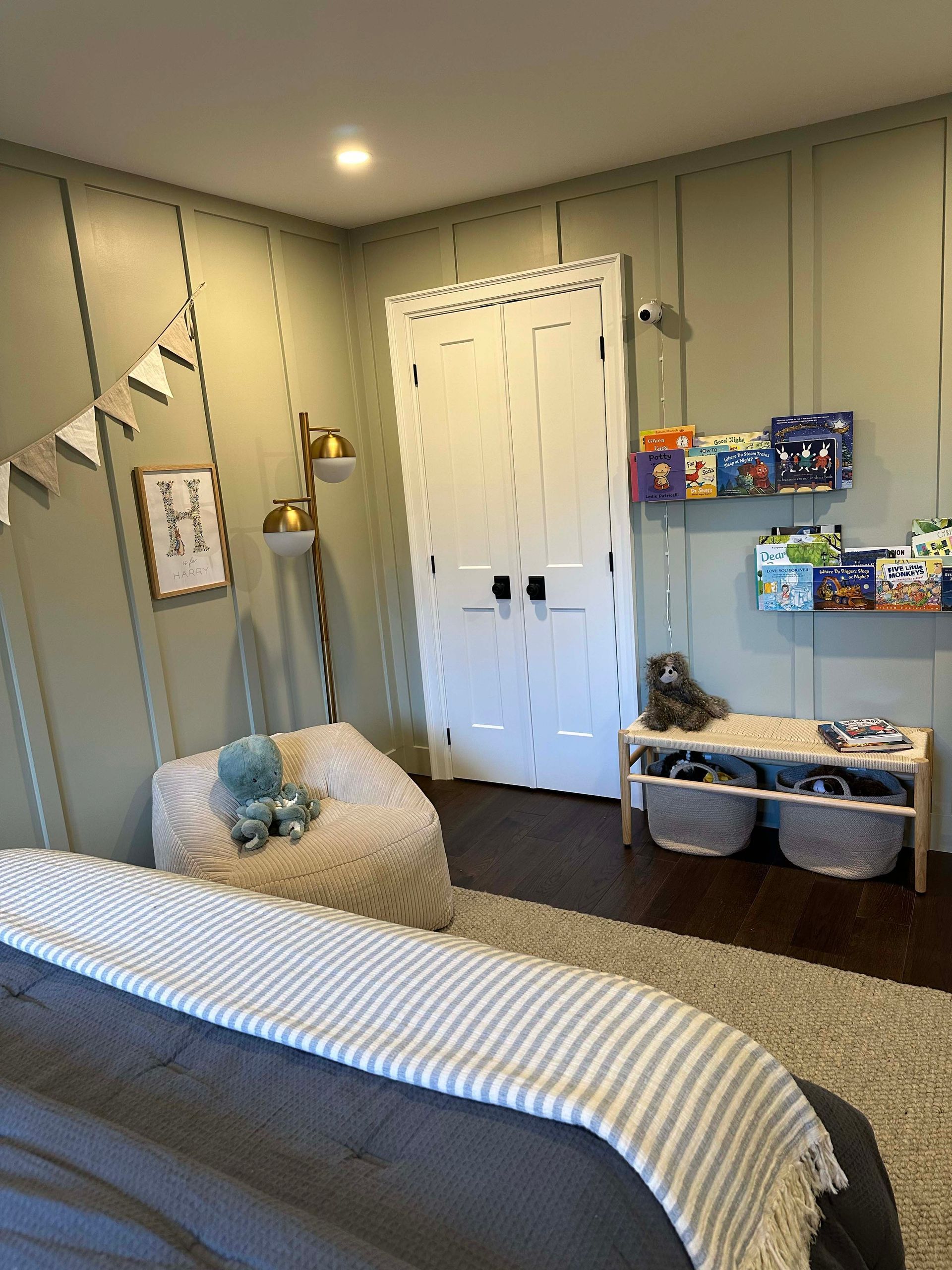 A bedroom with a bed , chair , bookshelf and shelves.
