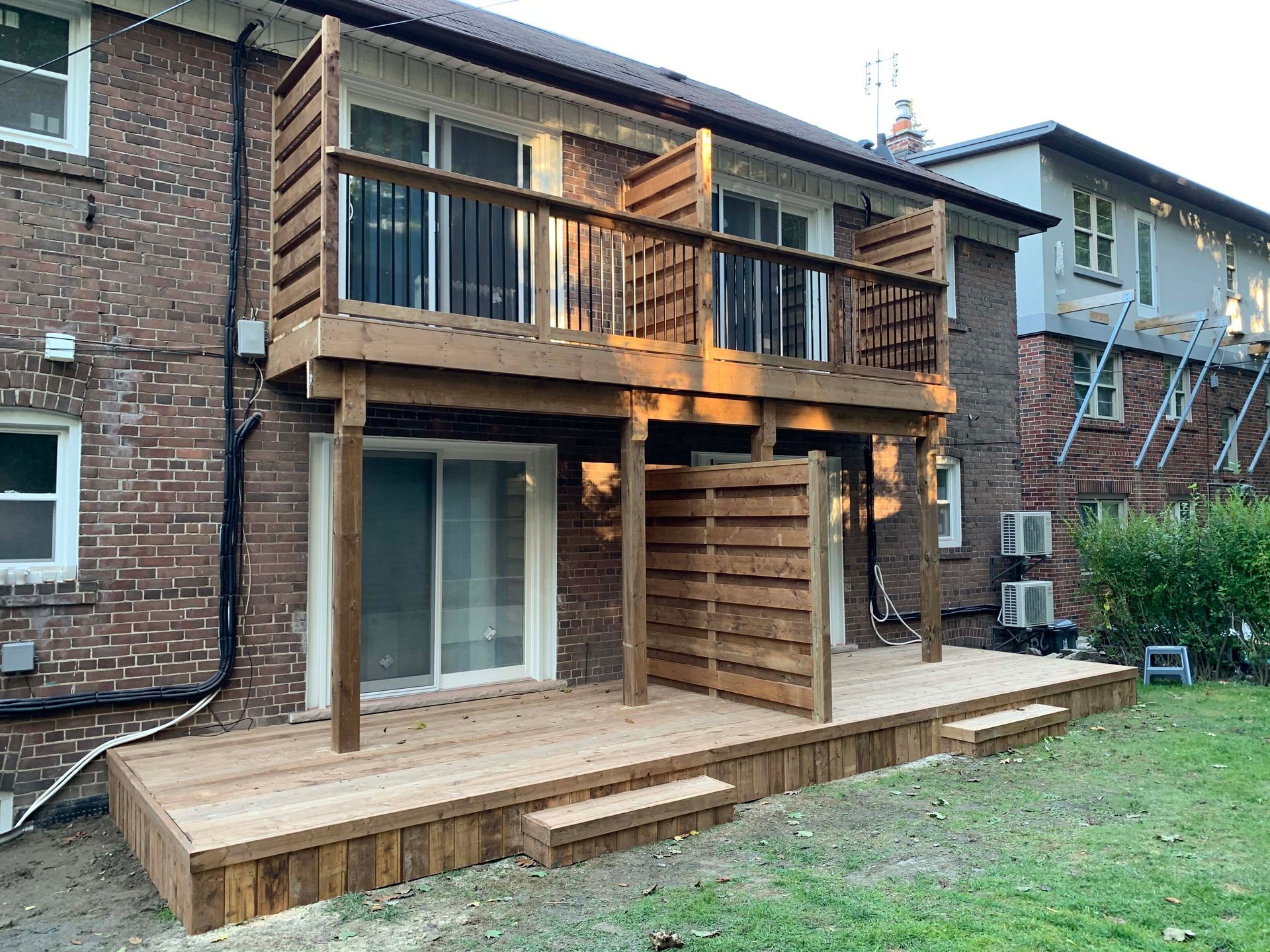A wooden deck is sitting in front of a brick building.