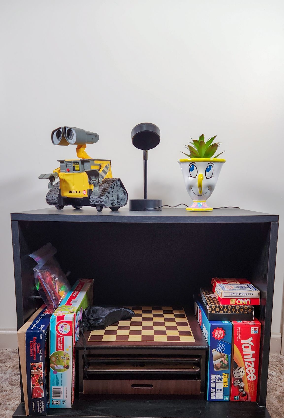 A table with a chess board and a wall e robot on it
