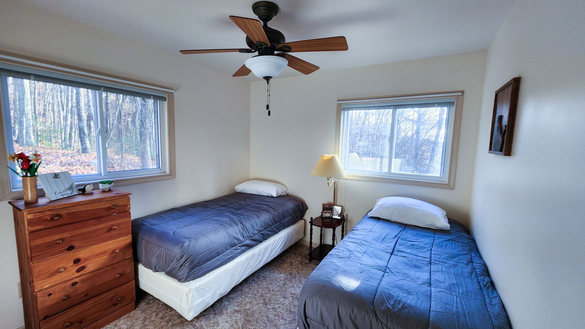 A bedroom with two beds and a ceiling fan.