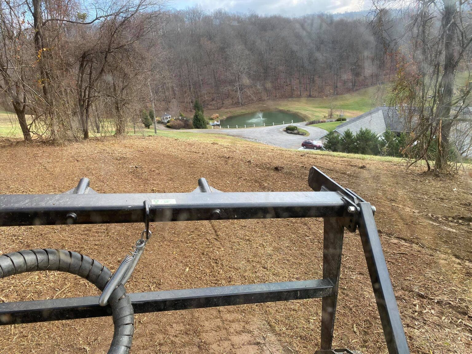 A view of a lush green hillside with a house in the background
