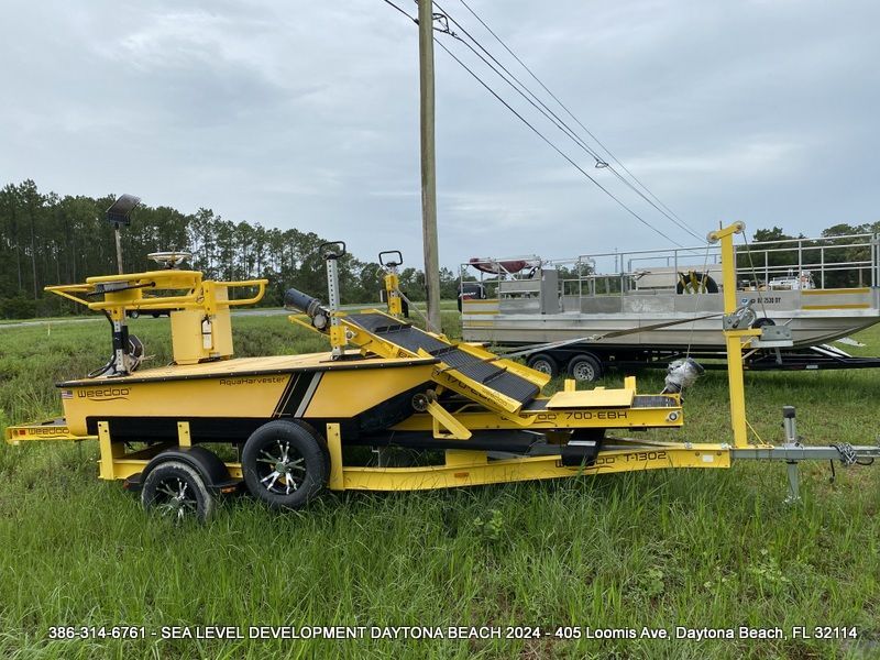 A yellow trailer is parked in a grassy field
