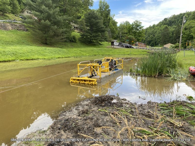 A yellow Dredge is floating on top of a muddy Municipal City Canal to remove silt from the bottom.