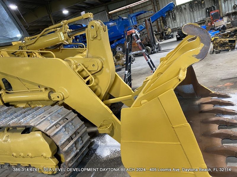 A yellow bulldozer is parked in a warehouse