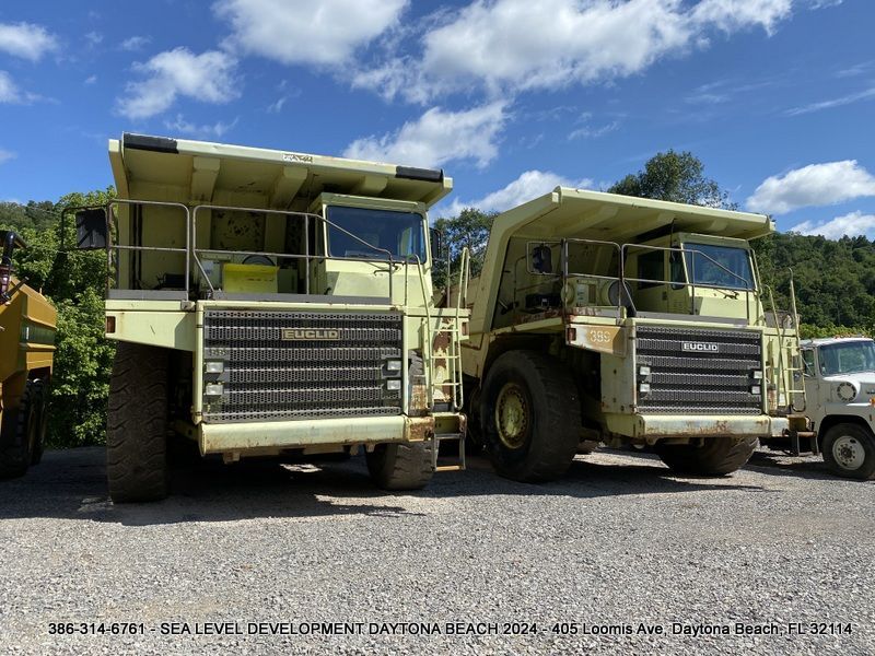 Two large dump trucks are parked next to each other