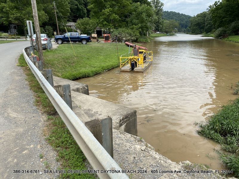 A flooded river with a yellow boat in the middle of it